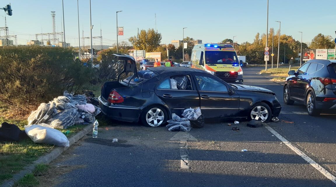 Csúnya baleset a 11. kerületben – Átszáguldott a Mercedes a piroson, egy Nissan Micraval ütközött, majd felugratott a járdaszegélyre és egy jelzőlámpát is kidöntött – Fotók