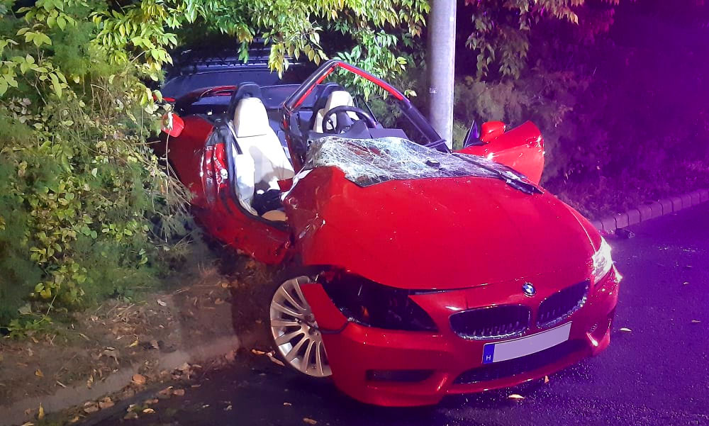 Durván összetört a piros luxus BMW, a sofőrt a nyitott tetejű autóból is csak feszítővágóval tudták kiemelni.