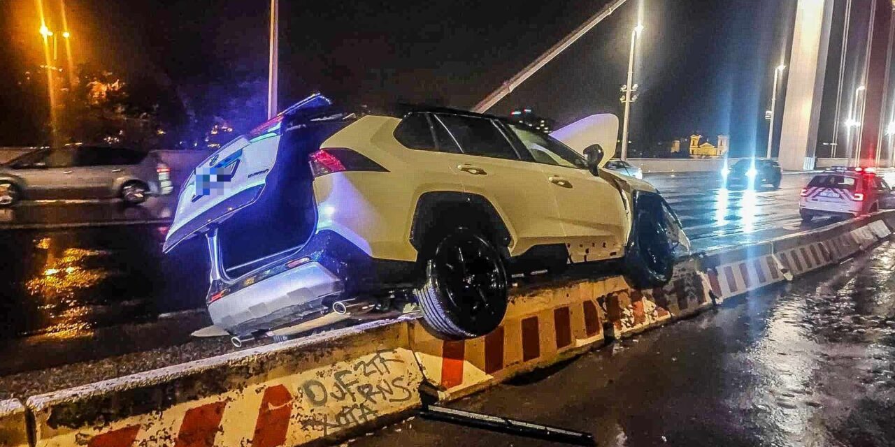 Látványos baleset az Erzsébet hídnál: a terelőelemek tetejére ugratott, majd fennakadt a Toyota HELYSZÍNI FOTÓKKAL!