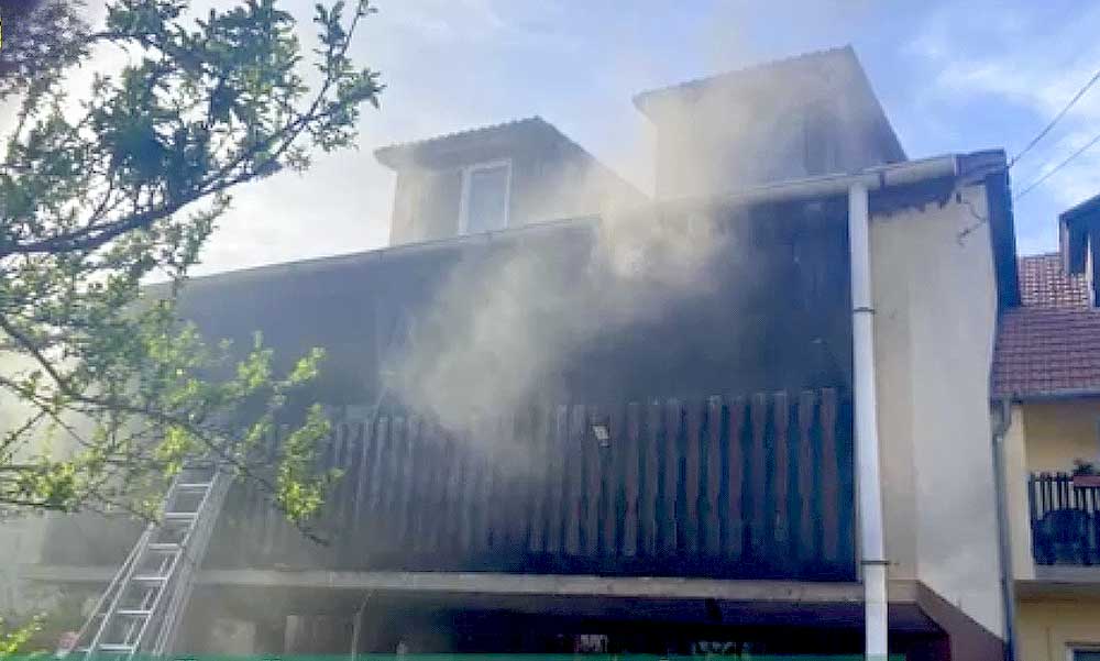 Lángoló házának erkélyén rekedt egy asszony, drámai mentőakció kezdődött – Videó
