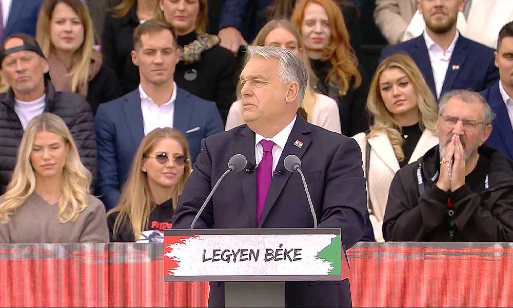 A boldogan tapsikoló Szabó Zsófival és a rózsafüzérrel imádkozó Eperjes Károllyal a háta mögött mondta el beszédét Orbán Viktor